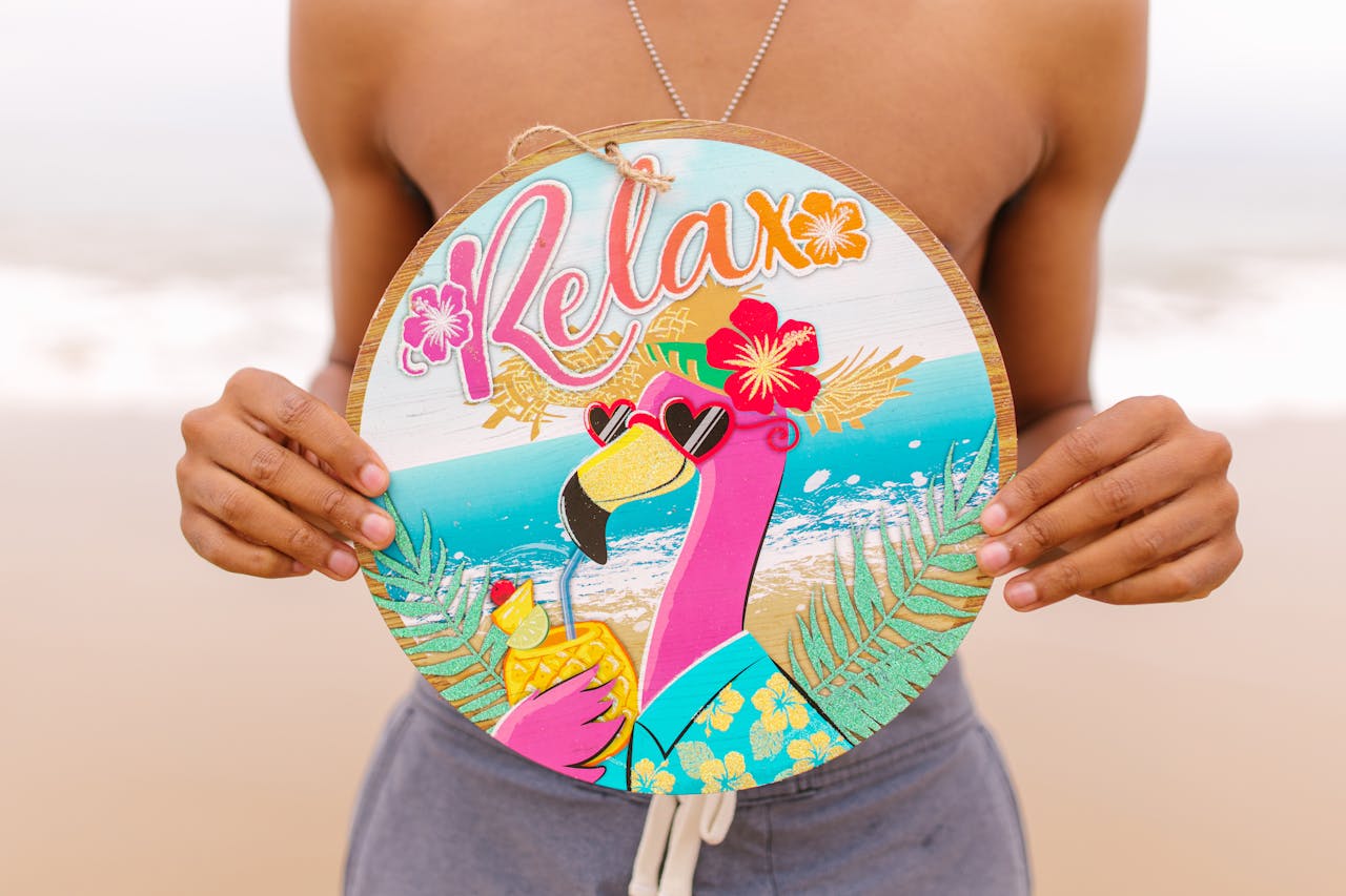 Close-up of a vibrant tropical beach sign with a flamingo, perfect for summer vibes.